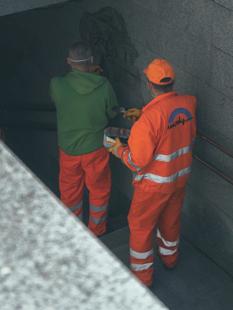 2 men in orange and green jacket working in Canada