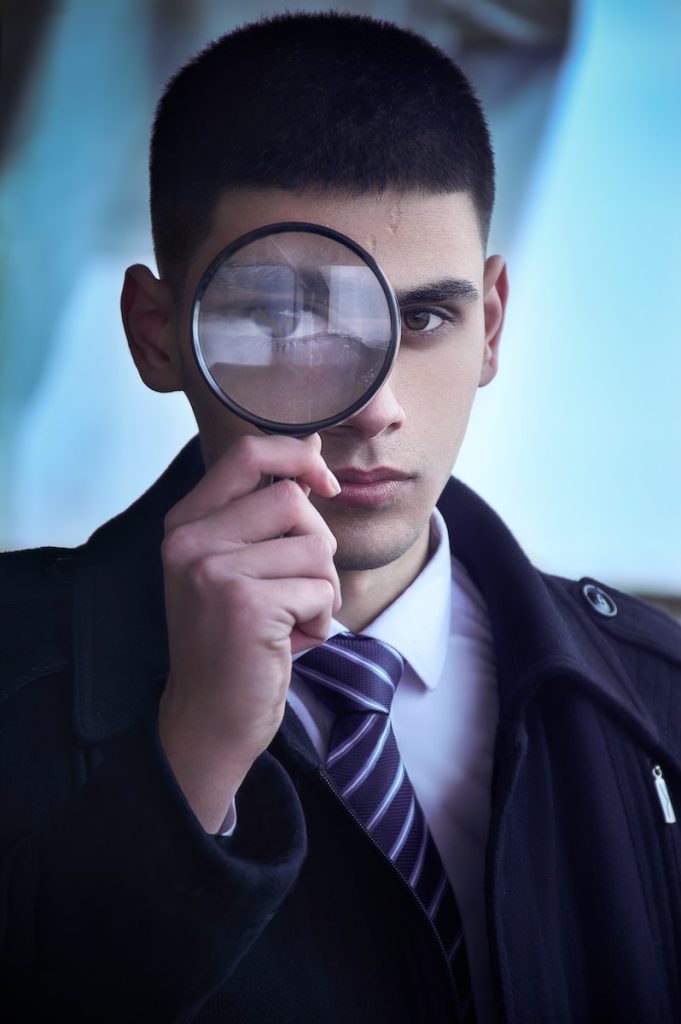 job search. man in black suit holding magnifying glass