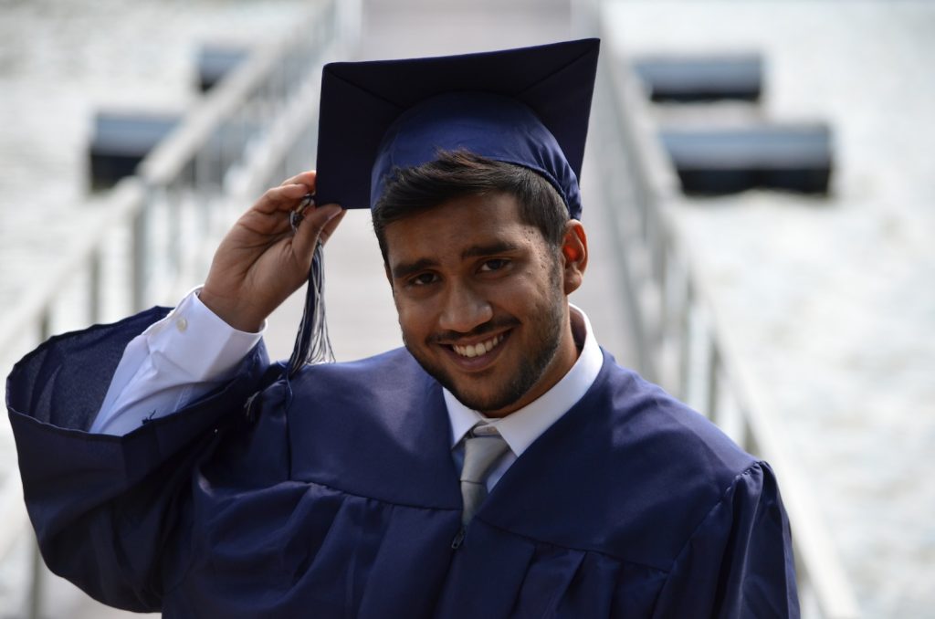 scholarship. man holding his graduation cap