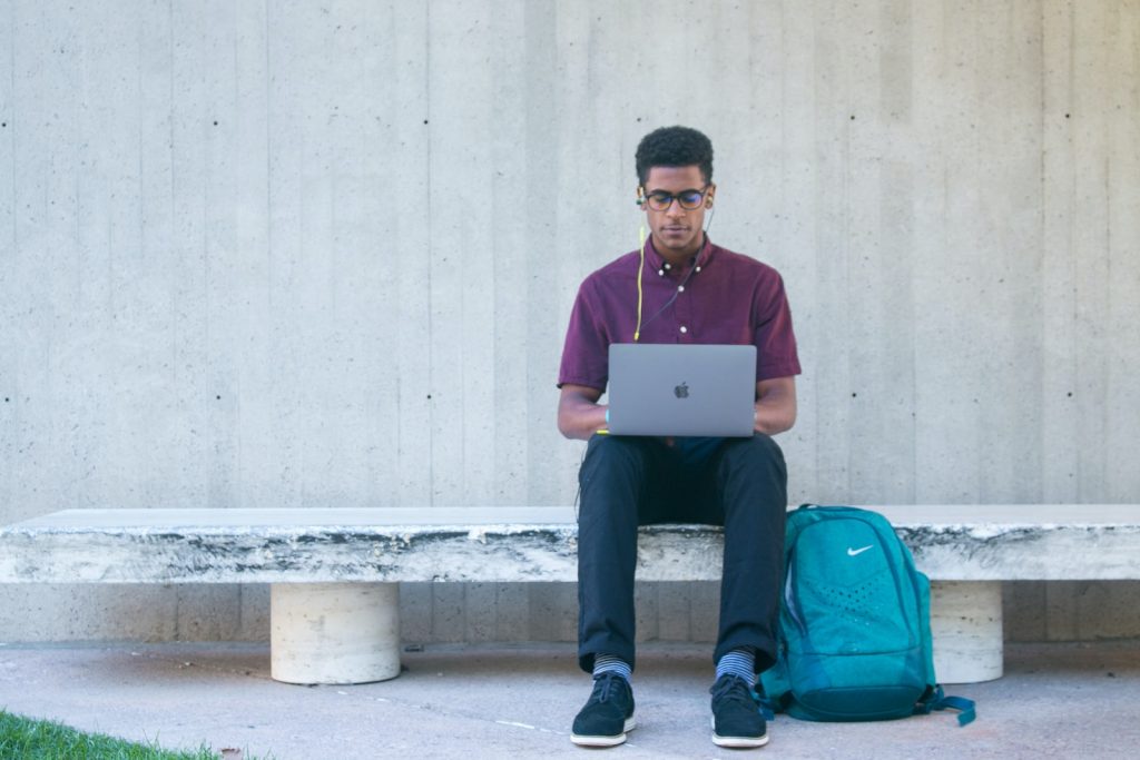 MEXT scholarship. A man sitting on a bench with a laptop