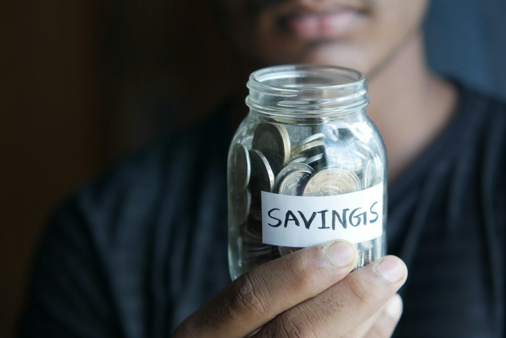 loan. a man holding a jar with a savings label on it