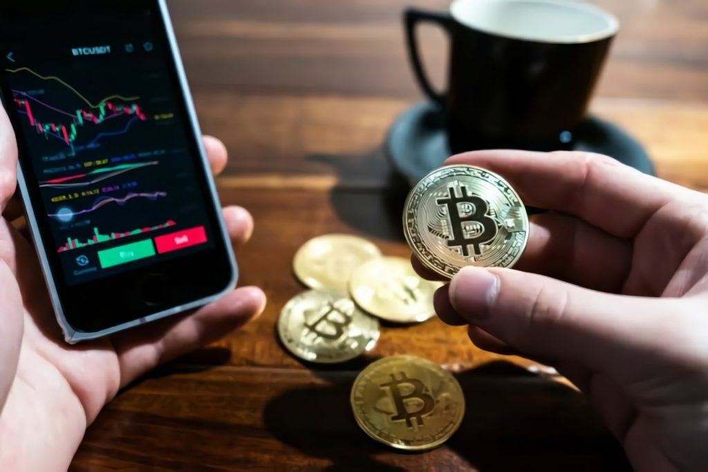 a person holding a bitcoin next to a cup of coffee