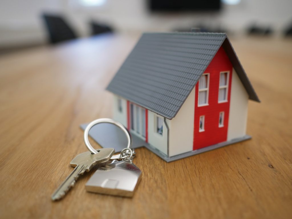 Mortgage. white and red wooden house miniature on brown table