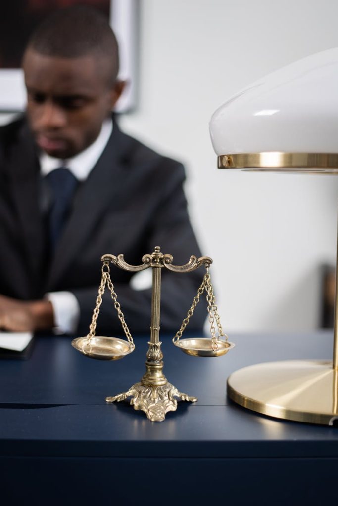 Immigration. Brass Colored Balance Scale on a Lawyer's Table